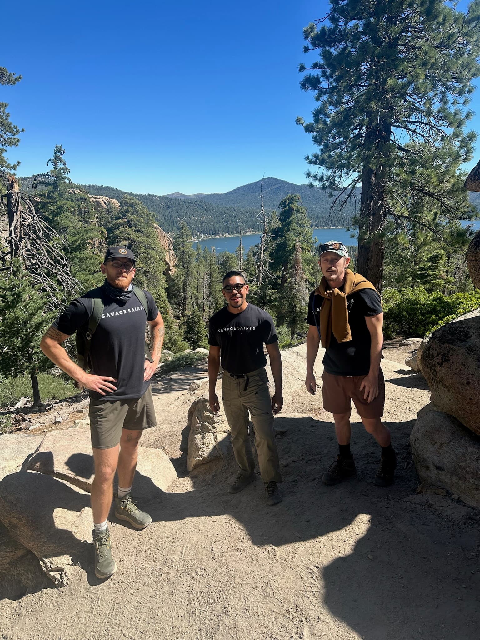 Another group of three individuals posing for a photo on a hiking trail